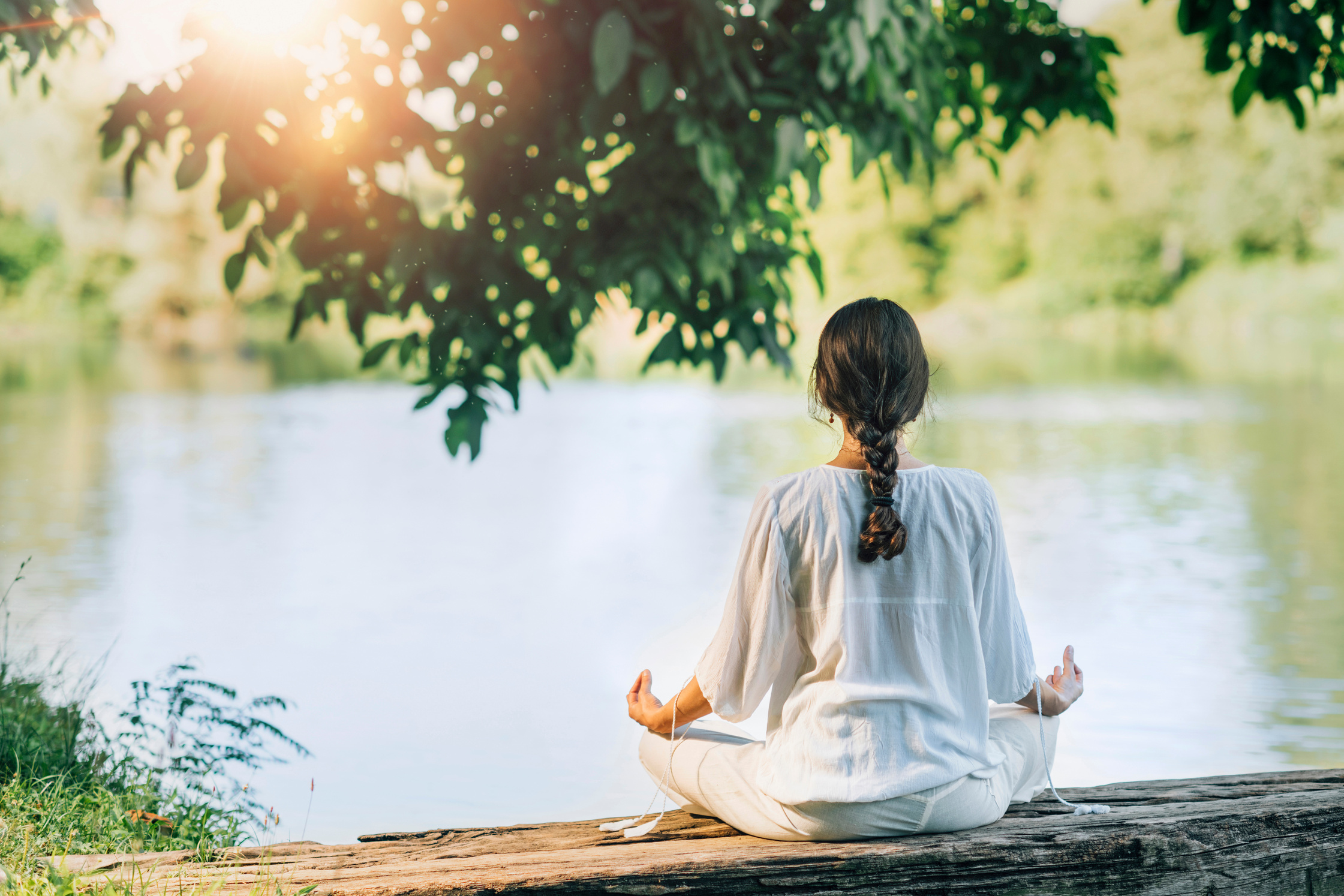 Yoga Retreat. Peaceful Young Woman Sitting In Lotus Position And Meditating By The Lake